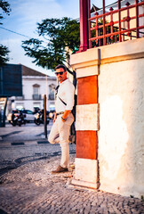 Man leaning against a building at sunset in downtown Faro, Algarve, Portugal