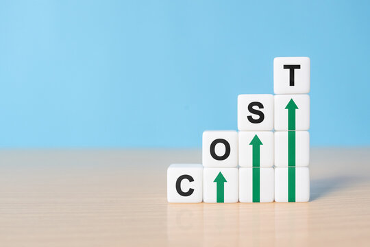 Cost increase and inflation concept. The word cost on dice with arrows going up.