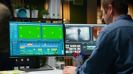 Green screen next to videographer cutting and editing video footage, web content development for cinematic montage. Color grading in post production software for new movie. Camera B.