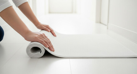 Top‑close hands placing a plain floor mat in a white hallway