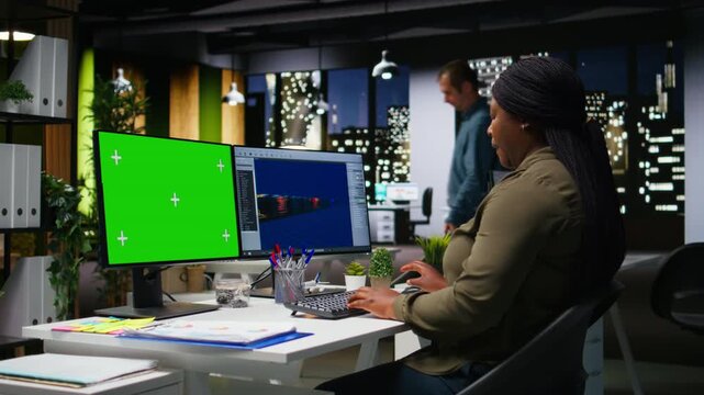 Green screen next to african american woman working on game developing, using multiple monitors at the office. Female engineer creating a futuristic spaceship station on software. Camera A.