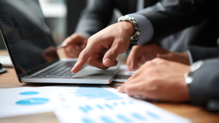 Business analysis meeting with laptop and charts for data presentation