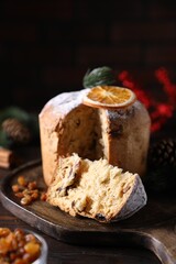 Christmas food. Delicious Panettone cake and festive decor on wooden table, closeup