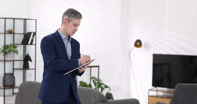 Real estate appraisal. Inspector with clipboard conducting property valuation at home