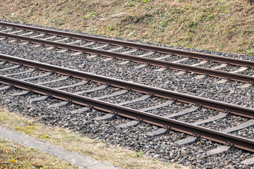 The train tracks are made of metal and gravel