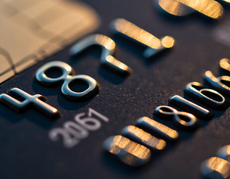 Close-up view of a credit card with embossed numbers and a blurred background.