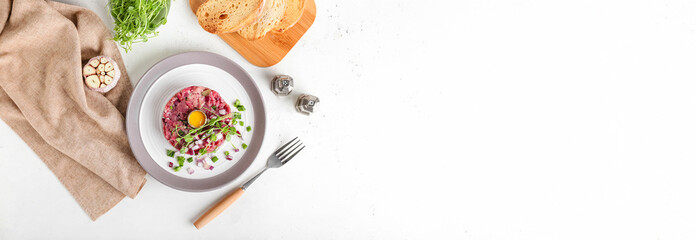 Plate with tasty beef tartare on light background