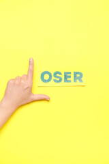 Woman showing loser gesture on yellow background