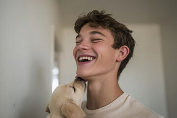 joyful boy laughs heartily as playful puppy licks his face radiating pure happiness
