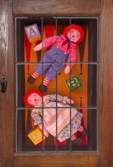 Toys displayed  on backgammon board. Raggedy Ann & Andy display well with old wood blocks. A collection of rag dolls is colorful. Handmade dolls are special.