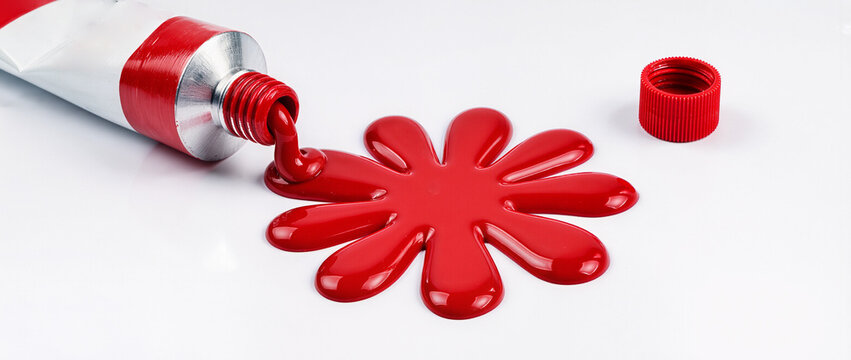 red paint tube making red flower on white background - Powered by Adobe