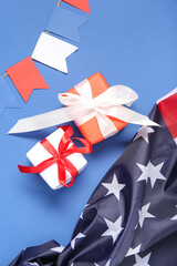 Gift boxes with USA flag and garland on blue background. American Independence Day