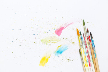 Artist's brushes and paints on white background