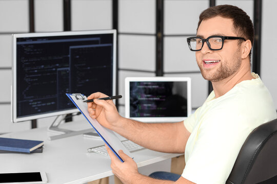 Portrait of male programmer with clipboard in office