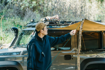 Male camper setting up a tent at a campsite in autumn and winter
