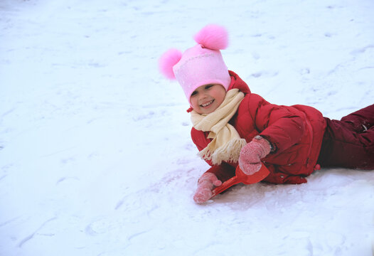 Child playing in the park on winter day having fun  and wallowing in the snow, she walking in snow on nice winter day, enjoy being outside, beauty nature, wonder and joy she feel looking fairy nature