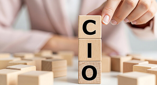 Woman arranges wooden blocks spelling cio representing chief information officer in a business strategy and leadership concept