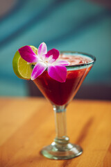 A cocktail with a lime and flower garnish at a modern well light restaurant