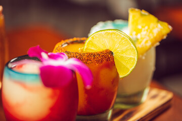 A flight of margaritas with a pineapple lime and flower garnish at a Mexican food restaurant  © heather linn photo