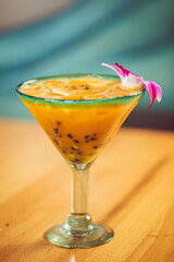 A passionfruit margarita with a flower garnish on a table at a modern Mexican food restaurant 