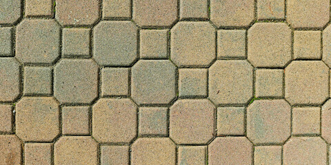Close-up of interlocking stone tiles forming an intricate geometric pattern in muted earth tones.