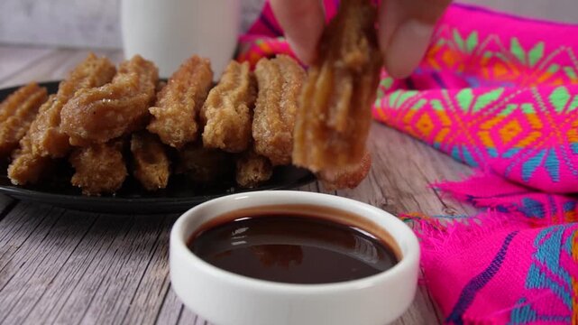 Applying chocolate to a churro in slow motion. Mexican food.