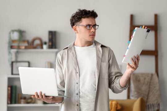 Male screenwriter with laptop and script in office