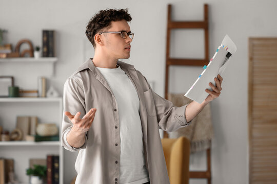 Male screenwriter reading script in office