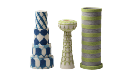 Three patterned cylindrical vases or candleholders stand together