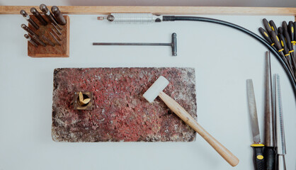 Artisan jewelry workshop tools arranged on a workbench.