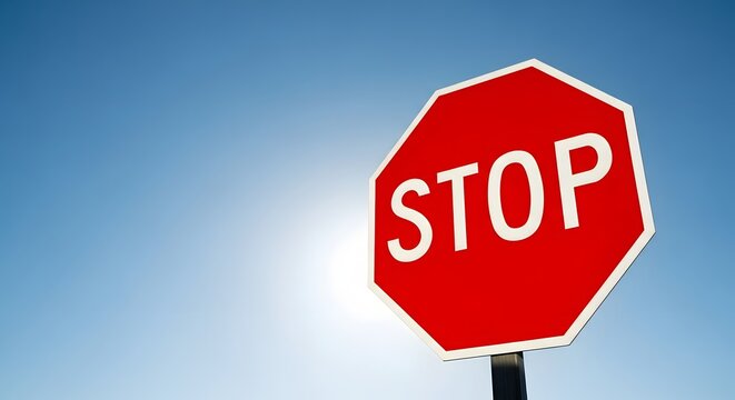 Bright blue sky with isolated red stop sign for traffic safety design and urban planning
