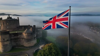 Majestic Scottish castle shrouded in mist with Union Jack waving proudly creates a sense of history and national pride perfect for travel videos