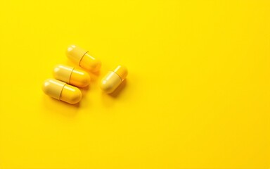 Close-up of yellow vitamin capsules on a yellow background. High quality