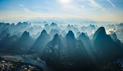 Aerial view of the famous karst mountain formations and winding river landscape in the morning fog near Guilin