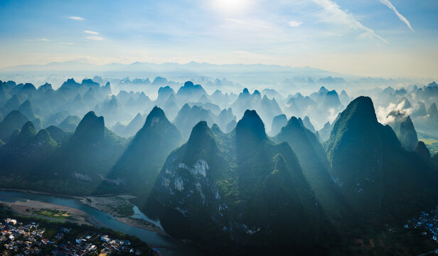 Aerial view of the famous karst mountain formations and winding river landscape in the morning fog near Guilin - Powered by Adobe