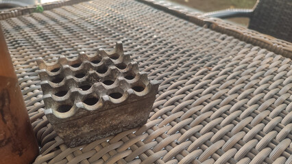 top view of metal ashtray on rattan woven table
