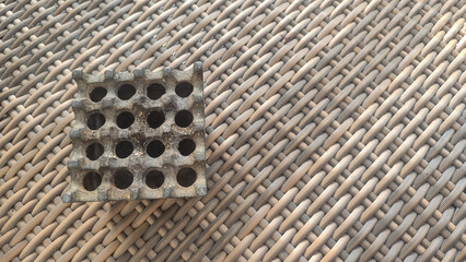 top view of metal ashtray on rattan woven table