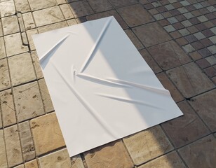 White paper with folds and shadows on a tiled surface.