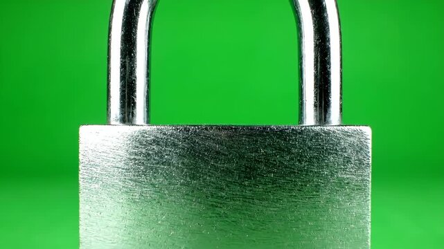 A close-up of a brushed metal padlock with a shiny shackle against a vibrant green background.