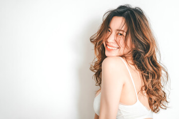 Naklejka premium A beautiful Asian woman with long flowing hair and radiant, dewy skin poses gracefully against a clean white background, capturing modern beauty with a soft, natural elegance.