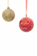 Two beautiful Christmas baubles seen against a plain white background. On one decoration is written Aroha which is the Maori word for Love.