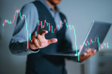 A professional man analyzing a digital candlestick chart with a laptop, showcasing stock market trends, investment data, and real-time financial analytics.