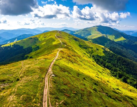 Aerial view of a mountain range with lush green slopes under blue skies