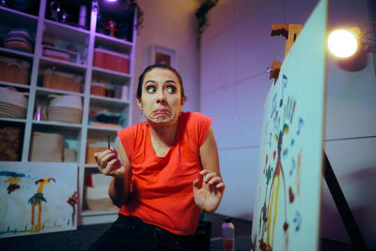 Funny Artist Making an Oops Face After Failing at Painting. Self critical painter making amusing goofy grimaces at her own work