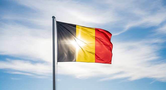 Belgian flag waving in the bright sun against a cloudy blue sky