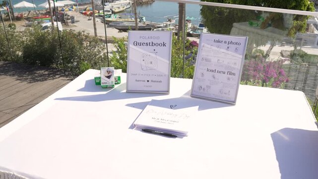 An inviting outdoor area by the marina features a guestbook and an instant photo station. Guests can leave messages and capture memories while enjoying lovely views.