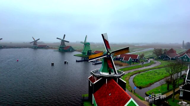 Misty morning reveals the charm of Zaanse Schans with historic windmills alongside peaceful waters. Visitors enjoy breathtaking views and traditional Dutch architecture.