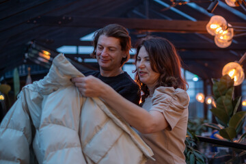 Middle-aged couple sharing a cozy moment in a cafe, enjoying evening ambiance, surrounded by warm lighting and stylish decor, creating a romantic atmosphere with connection