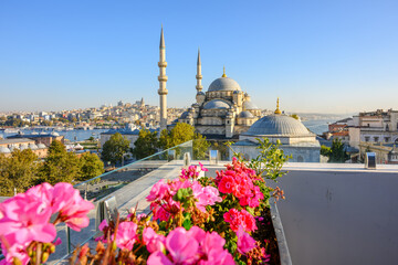 Fototapeta premium The New Yeni Mosque rises above the Eminonu district with the Bosphorus Strait and Galata Tower in view in the distance in Istanbul, Turkey.