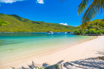 sandy beach in azure bay by the sea in summer day. A tropical luxury resort on an island in Asia. Panorama landscape with exotic ocean view